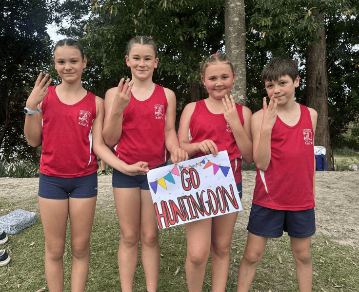 The school relay team holding up three fingers after coming third.
