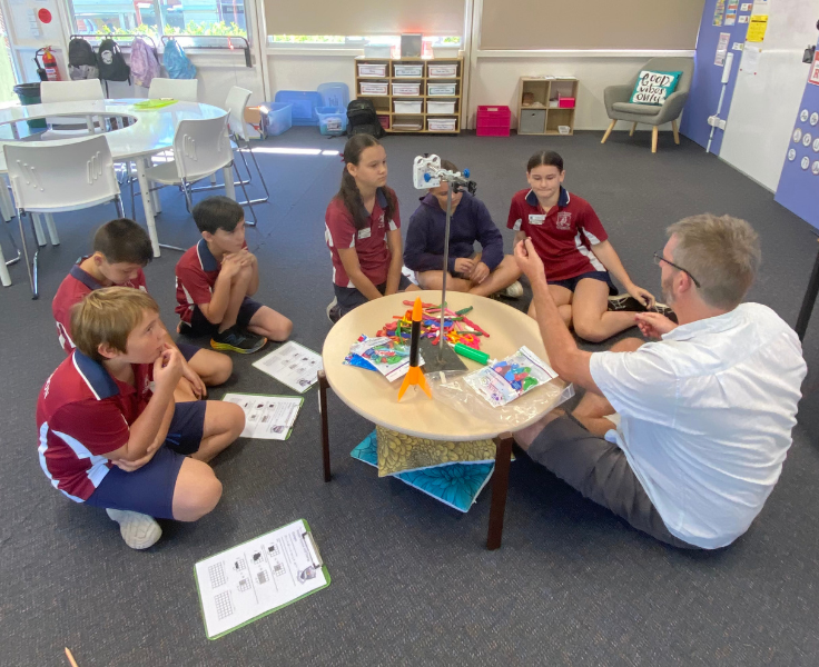Students with a teacher experimenting with a rocket.