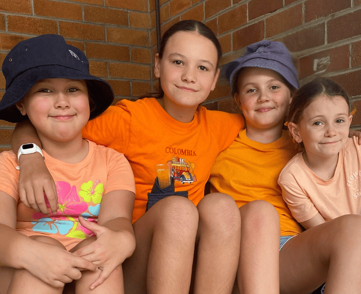 Four students wearing orange shirts.